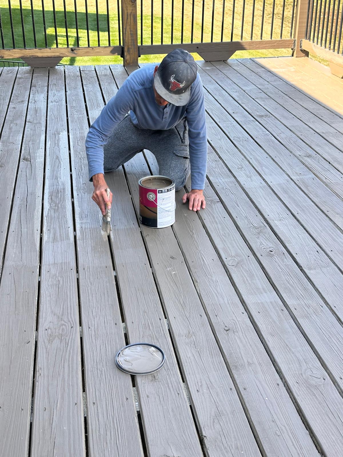 Crew member applying deck stain